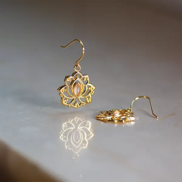 Goldene hängende Ohrringe mit einem rosa Stein