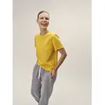 Lachendes, weibliches Model, mit Fokus auf das gelbe Rundhals-T-Shirt