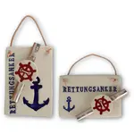 Ein weißer Tonanhänger mit maritimen Symbolen und angebrachtem eingerolltem Geldschein