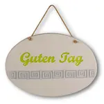 Weißes ovales Tonschild mit grüner Aufschrift "Guten Tag" mit Ornamenten