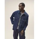 Männliches Model im dunklem Denimlook mit einer Jeansjacke und darunter einem grauen Oberteil
