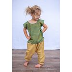 Kleines Mädchen mit einem grünen Kurzarm Top aus Baumwolle und einer grüne Hose stellt ihre Hände an die Hüfte