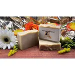 Beige Seife mit Aufdruck "kleopatramoment". Im Hintergrund liegen orangene Rosen.