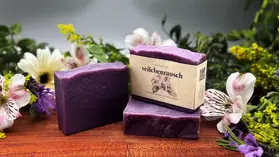 veilchenrausch Seife vor floralem Hintergrund