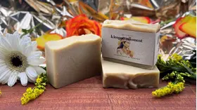 Beige Seife mit Aufdruck "kleopatramoment". Im Hintergrund liegen orangene Rosen.
