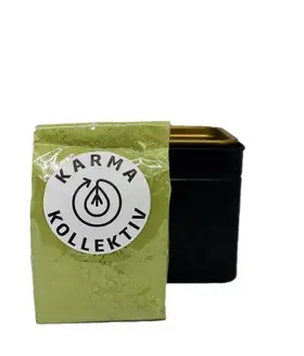 Verpacktes Matchapulver mit Karmakollektiv Logo. Dahiner eine passende Dose.