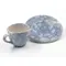 Komplettes Set mit blau-weiß glasierter Tasse und Untertasse mit weißem Hintergrund