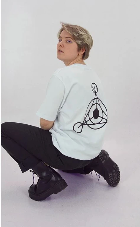 Frau im weißen T-Shirt mit schwarzem Logo auf dem Rücken